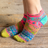 Colorful patterned socks worn on a wooden floor