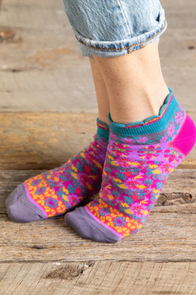 Colorful patterned socks worn on a wooden surface
