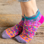 Colorful patterned socks worn on a wooden surface
