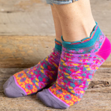 Colorful patterned socks worn on a wooden surface