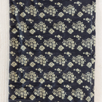 Navy blue fabric with white floral pattern on a wooden surface