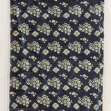 Navy blue fabric with white floral pattern on a wooden surface