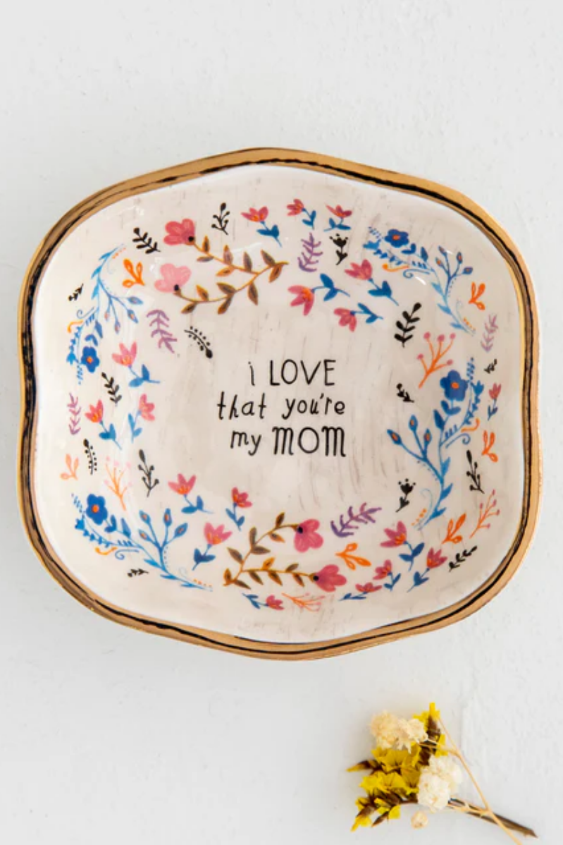 Decorative plate with floral design and text on a white background
