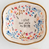 Decorative plate with floral design and text on a white background