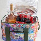 Colorful floral-patterned cooler bag with bottles and a phone inside on a white background