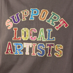 Gray sweatshirt with 'Support Local Artists' text in colorful letters.