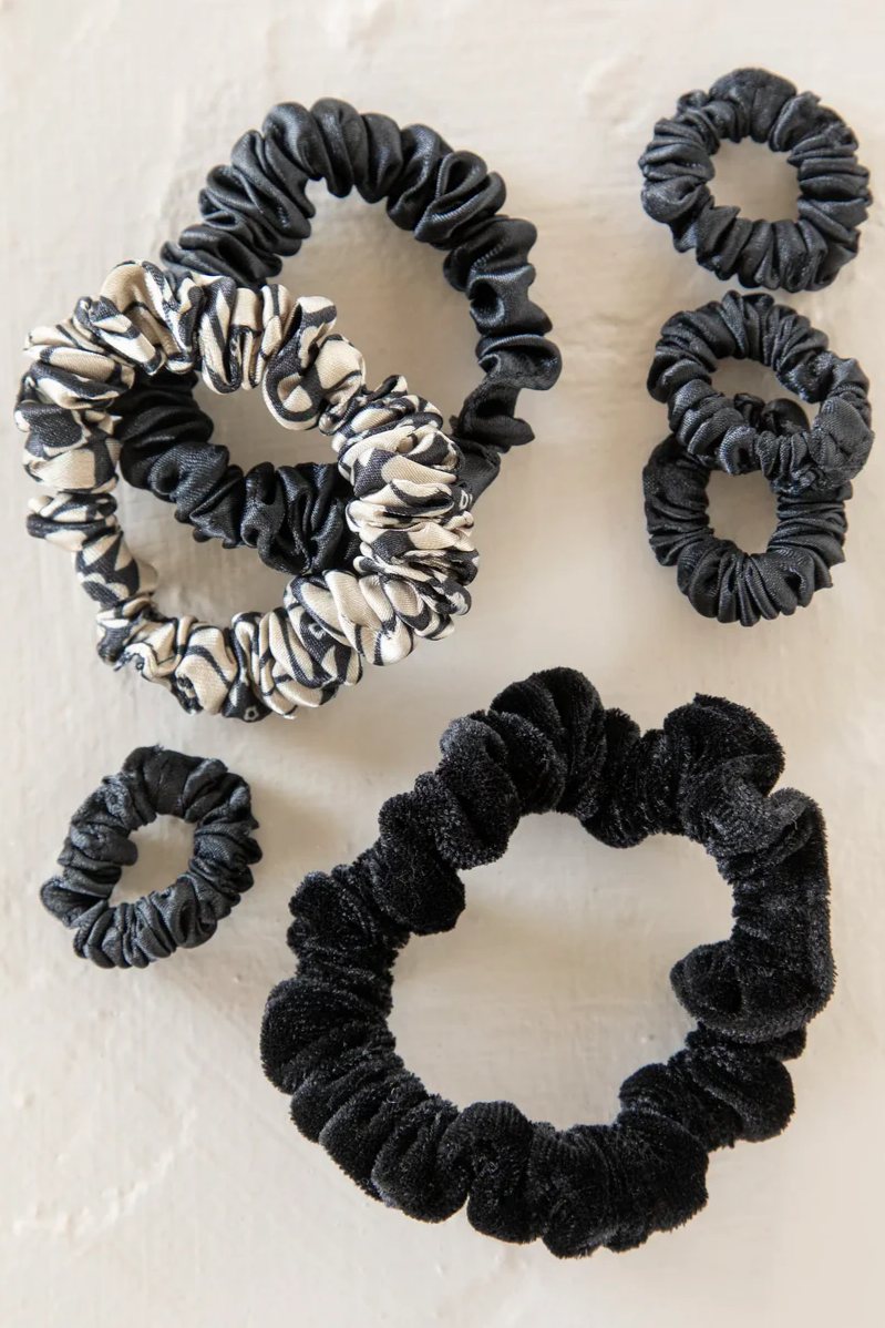 Set of black and patterned scrunchies on a light background