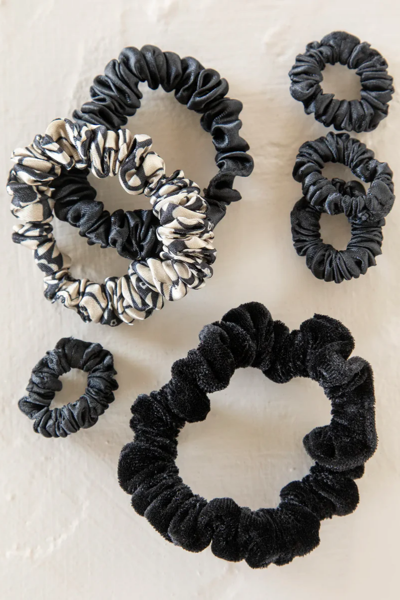 Set of black and patterned scrunchies on a light background