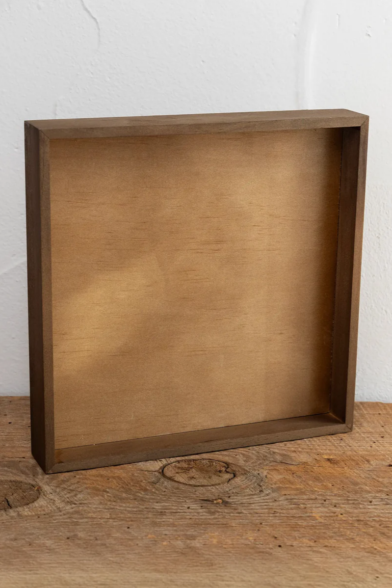 Wooden box on a wooden surface with a white wall background