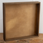 Wooden box on a wooden surface with a white wall background