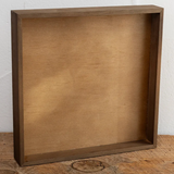 Wooden box on a wooden surface with a white wall background
