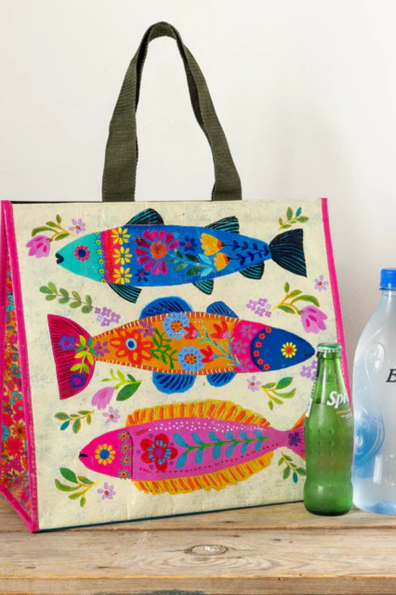 Colorful fish-patterned bag with two bottles on a wooden surface