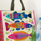 Colorful fish-patterned bag with two bottles on a wooden surface