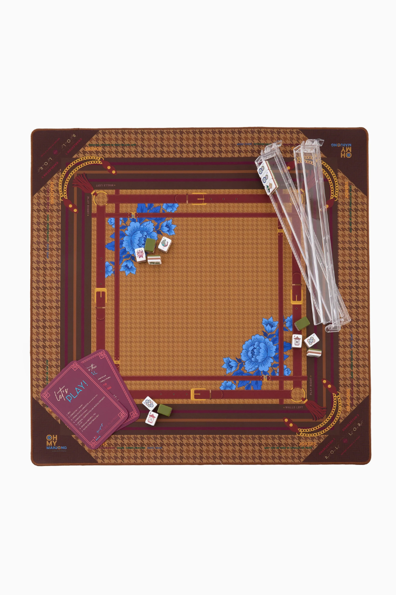 Mahjong game setup with dice and components on a brown and gold board