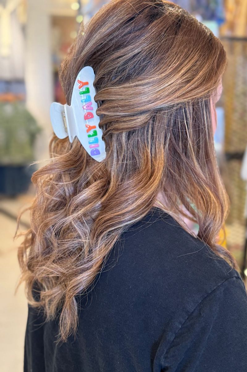Woman wearing a hairclip with her hair pulled half up and half down Hair Clip says, "Dilly Dally."