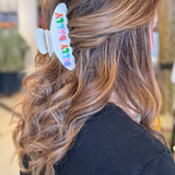 Woman wearing a hairclip with her hair pulled half up and half down Hair Clip says, "Dilly Dally."