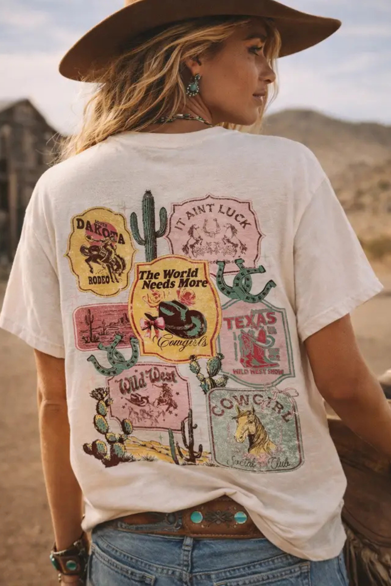 Person wearing a white t-shirt with graphic designs in a desert setting