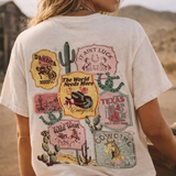 Person wearing a white t-shirt with graphic designs in a desert setting