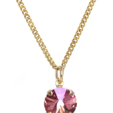 Gold necklace with a pink gemstone pendant on a white background