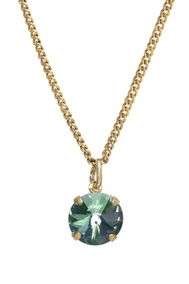 Gold necklace with a green gemstone pendant on a white background