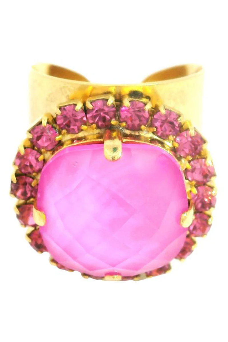 Gold ring with a pink gemstone and smaller pink stones on a white background
