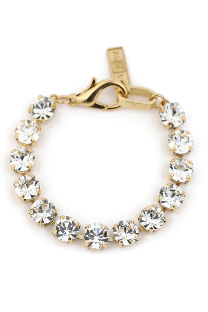 Gold bracelet with clear gemstones on a white background