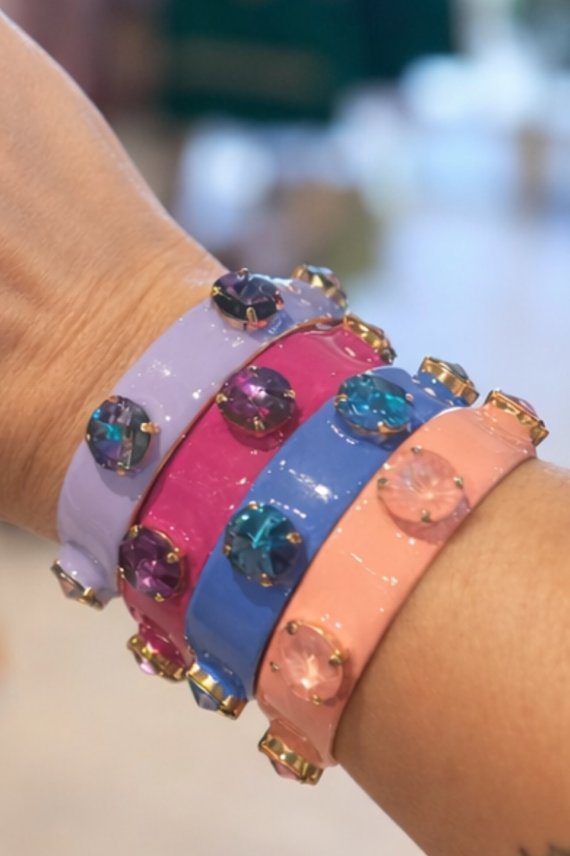 Colorful bracelets with gemstones on a wrist against a blurred background