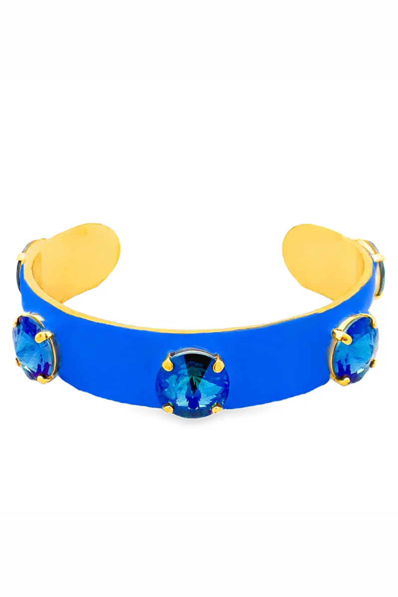 Blue cuff bracelet with gold accents and blue gemstones on a white background