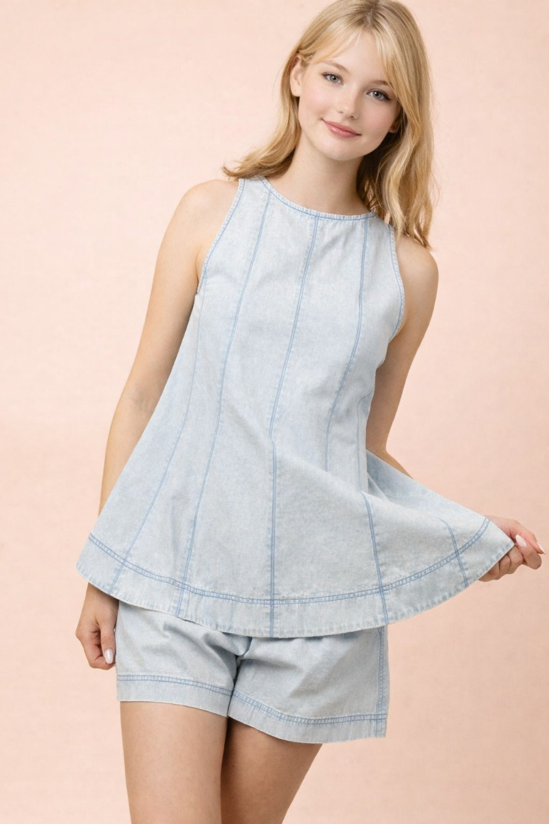 Woman wearing a light blue sleeveless top and shorts set on a pink background