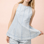 Woman wearing a light blue sleeveless top and shorts set on a pink background
