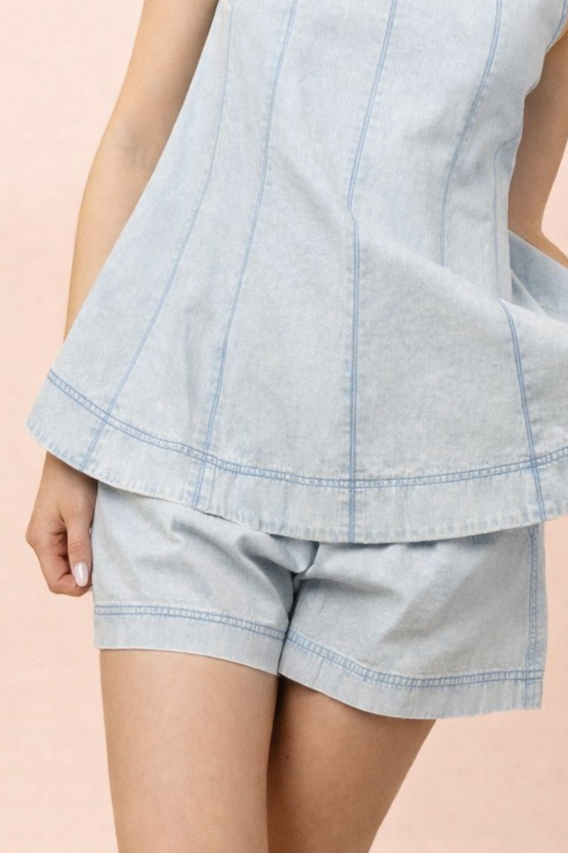 Light blue top and shorts on a person against a pink background
