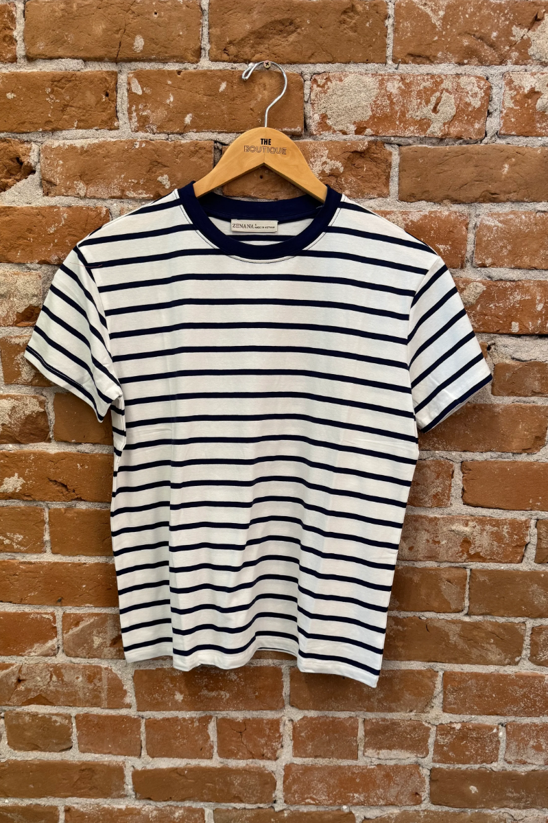 Striped t-shirt on a wooden hanger against a brick wall