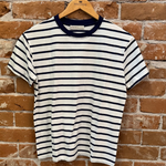 Striped t-shirt on a wooden hanger against a brick wall