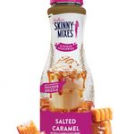 Bottle of Skinny Mixes Salted Caramel sauce with packaging and caramel candies on a white background