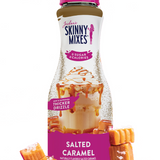 Bottle of Skinny Mixes Salted Caramel sauce with packaging and caramel candies on a white background