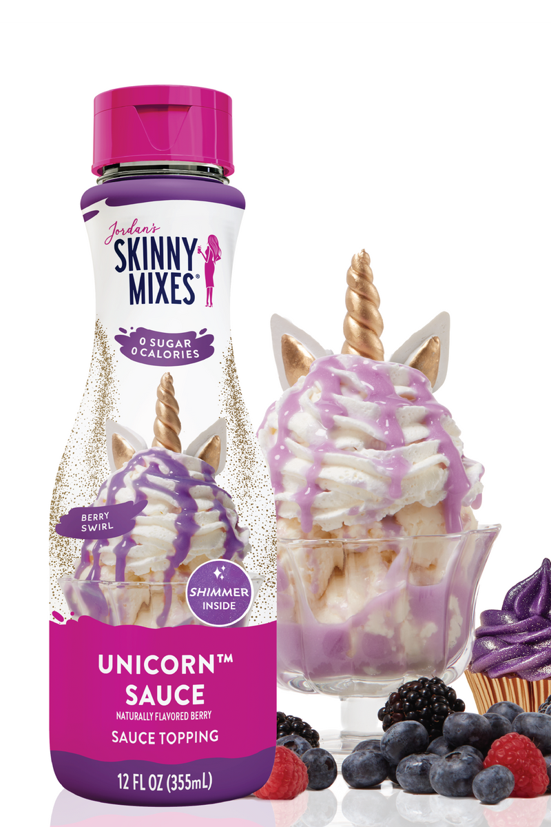 Skinny Mixes Unicorn sauce bottle with dessert items on a white background