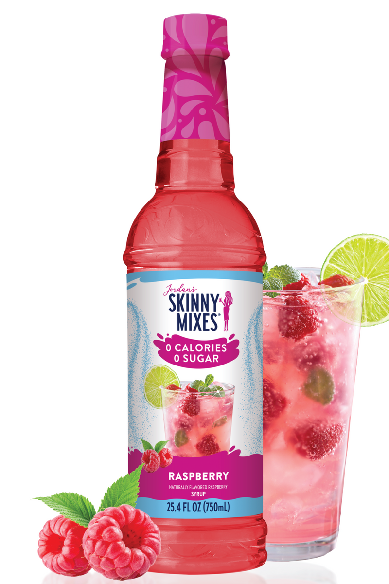 Skinny Mixes raspberry syrup bottle with a glass of raspberry juice on a white background
