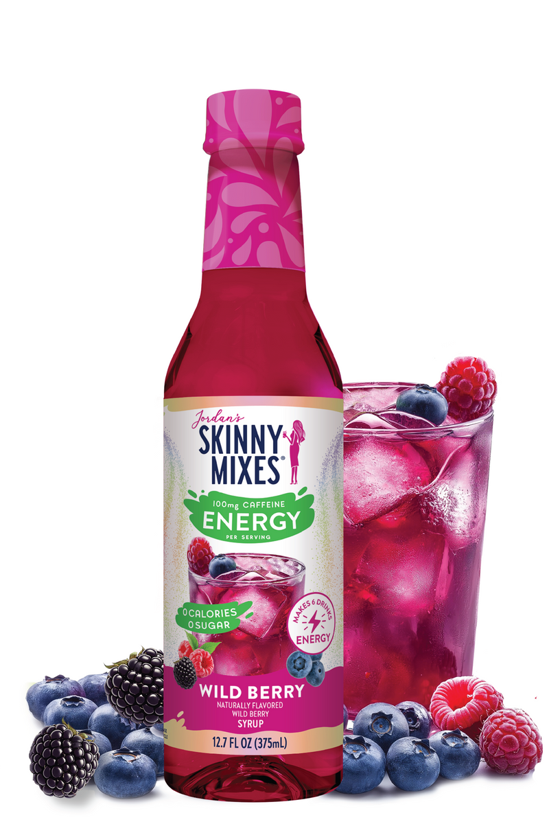 Skinny Mixes Wild Berry drink mix bottle with a glass of mixed berry drink and berries on a white background