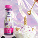 Skinny Mixes Unicorn Sauce bottle with a dessert and blackberries on a colorful background