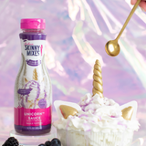 Skinny Mixes Unicorn Sauce bottle with a dessert and blackberries on a colorful background