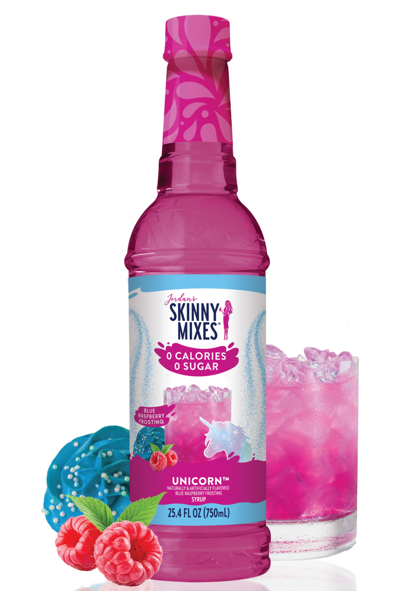 Pink bottle of Skinny Mixes Unicorn syrup with a glass of pink drink and berries on a white background