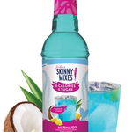Bottle of Skinny Mixes Mermaid syrup with a glass of blue drink, pineapple, and coconut on a white background