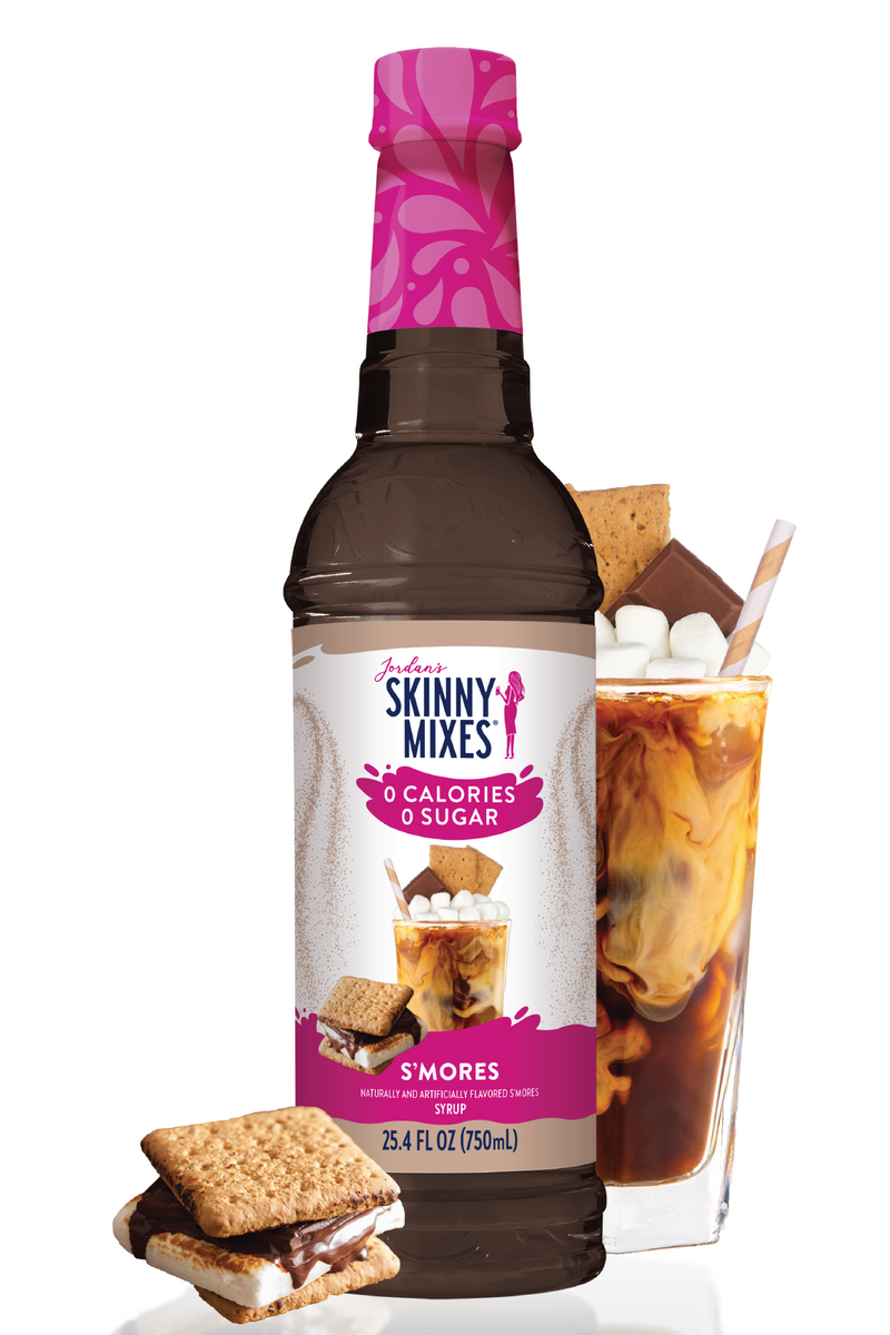 Skinny Mixes S'mores syrup bottle with a glass of iced coffee and s'mores on a white background