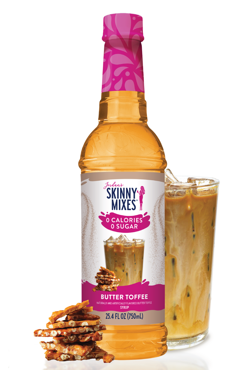 Skinny Mixes Butter Toffee syrup bottle with a glass of syrup and pretzels on a white background
