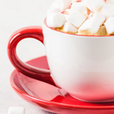 White mug with red handle filled with hot chocolate and marshmallows on a red saucer.