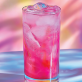 Glass of pink drink with ice cubes on a colorful background